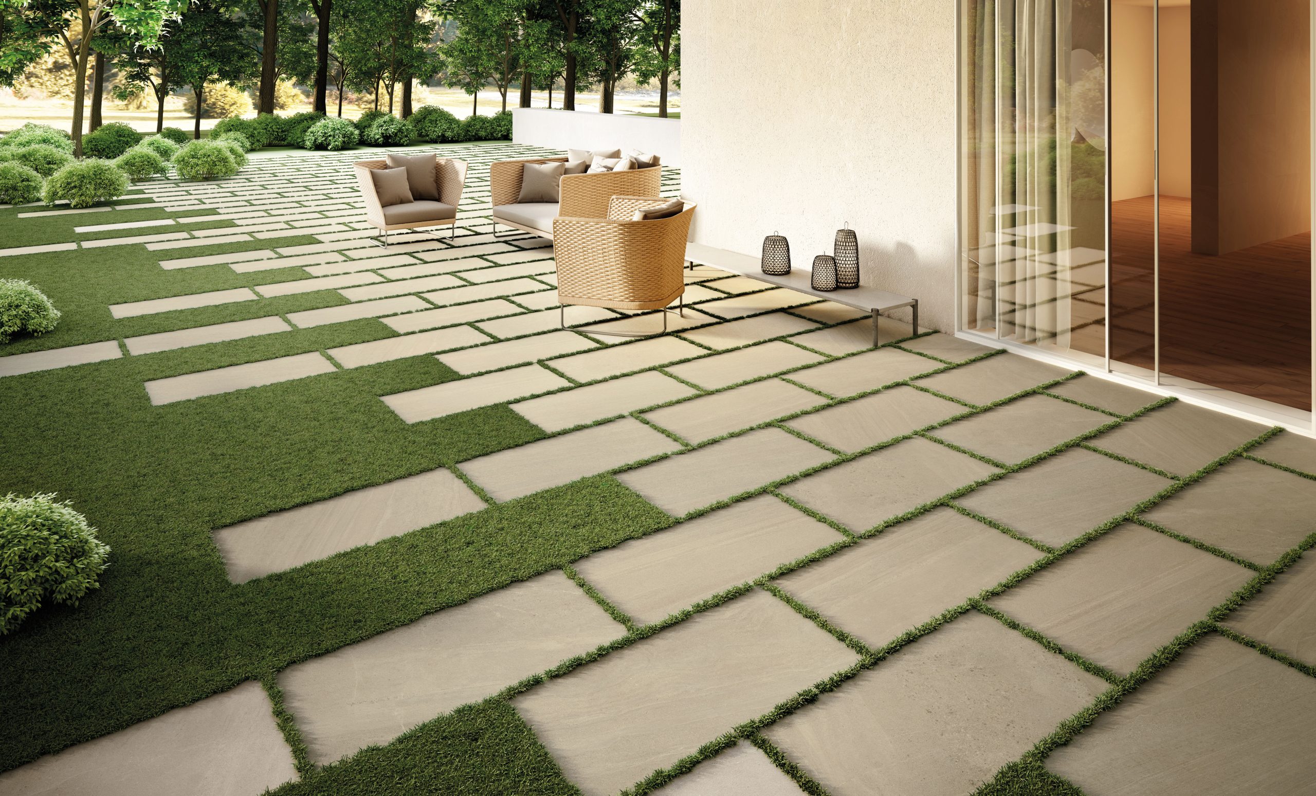 Ljus utomhusklinker från Nordic Stone på en uteplats med gräspartier och träd.